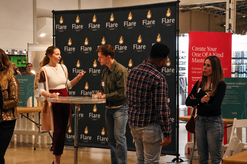 Singles talking at a Flare Events gathering in front of Flare branding