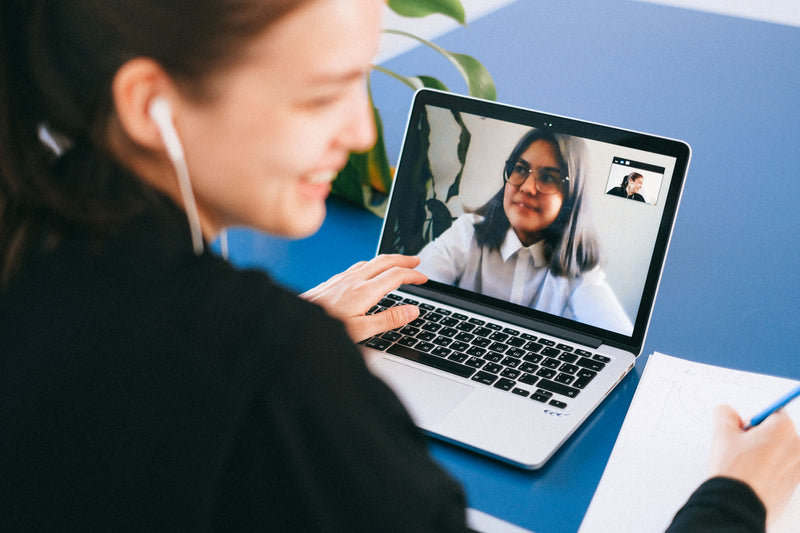 Person taking notes during a video call, representing flexible online dating coaching in Canada